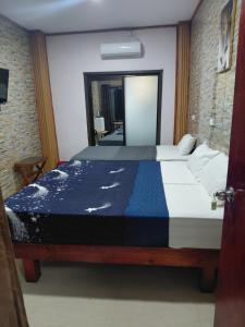 a bedroom with a bed with a blue and white comforter at Standard - Bluelight Village Hotel in Nadi