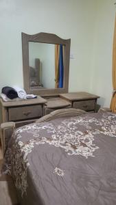 a bedroom with a bed with a dresser and a mirror at Enjoy Life Holidays in Andrés
