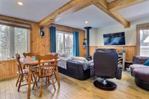 a living room with a couch and a table and chairs at Spa & Sauna - Chalet de l'Ours noir in Notre-Dame-Des-Bois