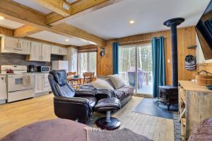 a living room with a leather chair and a couch at Spa & Sauna - Chalet de l'Ours noir in Notre-Dame-Des-Bois