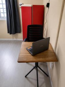a laptop computer sitting on top of a wooden table at Mala & Café in Curitiba