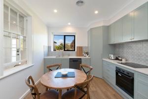 a kitchen with a wooden table and chairs in a kitchen at Lava House WIFI central heating cooling CBD in Warrnambool