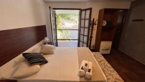 a bedroom with a large bed and a large window at Pousada Castelinho in São Sebastião