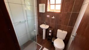 a bathroom with a toilet and a sink and a shower at Pousada Castelinho in São Sebastião