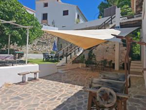 a patio with an umbrella and chairs and a table at La Casa del Agua in Montefrío