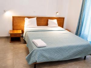 a bedroom with a large bed with a blue bedspread at Akenon Appart Hotel in Ouagadougou