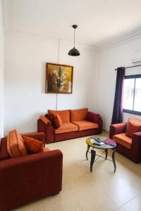 a living room with two couches and a table at Akenon Appart Hotel in Ouagadougou