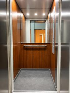 an elevator door with a mirror in a building at Akenon Appart Hotel in Ouagadougou +3 photos