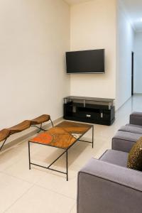 a living room with a tv and a coffee table at Akenon Appart Hotel in Ouagadougou