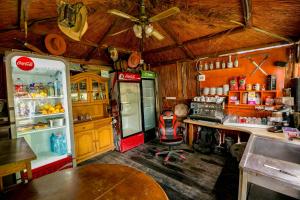 a kitchen with a coca cola refrigerator and a table at Casa Yachi Vama Veche in Vama Veche