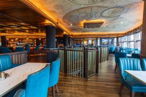 a restaurant with blue chairs and tables and a ceiling at Tara Hotel in Killybegs