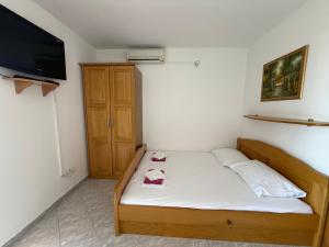 a small bedroom with a bed and a flat screen tv at Apartmani Kovačić in Kraj