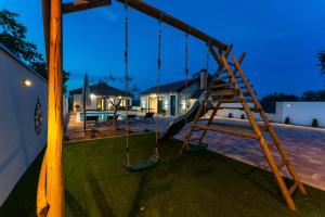 a playground with a ladder and a swing at Kuća za odmor Leona in Dušić