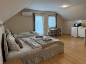 a bedroom with a bed and a kitchen with a table at Akácfa B&B in Zalakaros