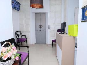 a waiting room with purple chairs and a television at TY Hotel in Kuala Terengganu