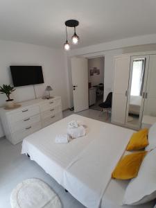 a bedroom with a large white bed and a tv at Garsoniera Serena in Saturn