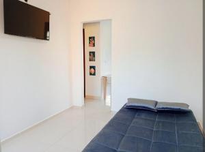 a bedroom with a bed and a flat screen tv at Casa 2 quartos com garagem in Divinópolis