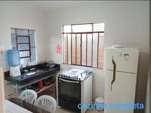 a kitchen with a stove and a refrigerator at Casa 2 quartos com garagem in Divinópolis
