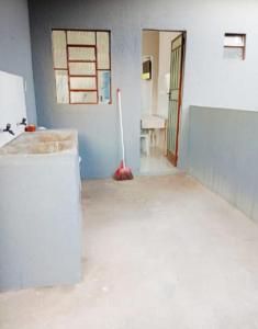 an empty room with a mop in the middle of it at Casa 2 quartos com garagem in Divinópolis