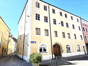 a large white building with a door on a street at ALTSTADT-Apartmenthaus BOGENSPERGER in Braunau am Inn