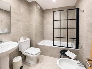 a bathroom with a toilet and a sink and a tub at Hotel Musher in Pas de la Casa +45 photos