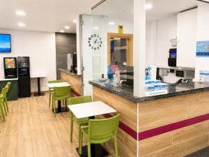 a restaurant with green chairs and a counter at Hotel Musher in Pas de la Casa