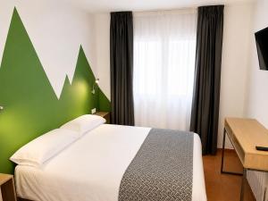 a bedroom with a bed with a green wall at Hotel Musher in Pas de la Casa