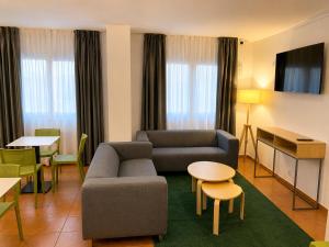 a living room with a couch and a table and chairs at Hotel Musher in Pas de la Casa