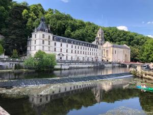 a large building next to a river with a bridge at Gîte 4 personnes in Brantôme