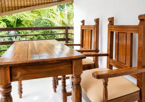 a wooden table and chairs in a room with a window at Aditi in Thekkady