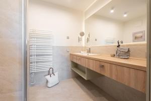 a bathroom with a sink and a mirror at Apartmenthaus Resort Kranichsruh in Fuhlendorf +120 photos