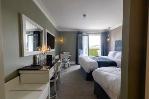 a hotel room with two beds and a desk at Tara Hotel in Killybegs +66 photos