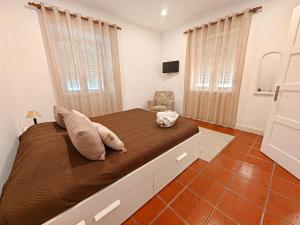 a bedroom with a large bed and a chair at Casa Teles in Peso da Régua