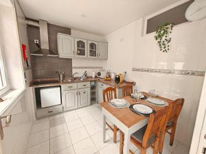 a kitchen with a wooden table and chairs and a kitchen with a sink at Casa Teles in Peso da Régua
