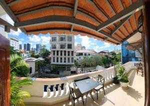 a balcony with a table and chairs and a view of the city at Poolside Villa in Phnom Penh