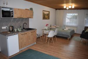 a kitchen and a living room with a table and a bed at Pokoje gościnne u Kasecki in Murzasichle