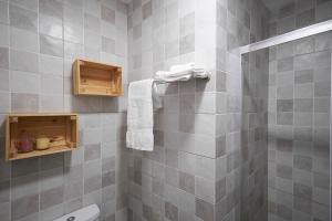 a gray tiled bathroom with a toilet and towels at Hostal Puente de Hierro in Logroño +20 photos
