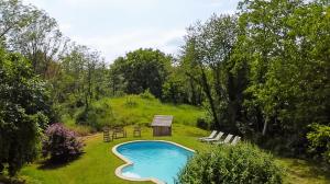 ein Swimmingpool in einem Garten mit Stühlen und Bäumen in der Unterkunft Chambre d'Hotes Cugnac in Sainte-Sabine