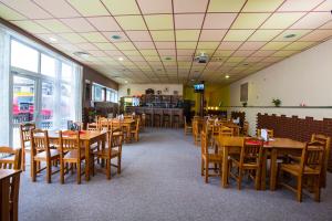 uma sala de jantar com mesas e cadeiras de madeira em Sportovní Centrum Semily em Semily