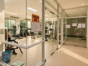 a gym with glass doors and exercise bikes at Apartment Phuket Old Town Fast Wifi Netflix Pool Gym Cityview in Phuket