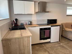 a small kitchen with a sink and a refrigerator at Les champs étoilé in Morschwiller