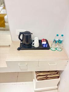 a counter with a tea kettle and water bottles at The Byke Embassy - Surat in Surat