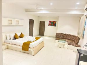 a bedroom with a large bed and a couch at The Byke Embassy - Surat in Surat +18 photos