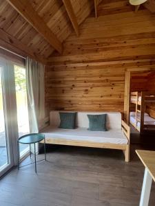 a bed in a room with a wooden wall at Càmping l'Alguer in Les Planes d'Hostoles +62 photos