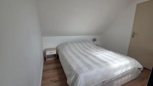 a bedroom with a white bed and a wooden floor at Maison bord de Loire Listing B in Saint-Rémy-la-Varenne