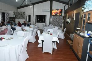 a dining room with white tables and white chairs at Standard - Bluelight Village Hotel in Nadi