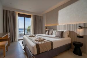 a hotel room with a large bed and a balcony at Hotel Areti in Neos Marmaras
