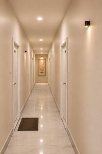 a hallway with white walls and white floors and a hallway with doors at Hotel Vaarahi Chanda Nagar, Near Hitech City in Hyderabad