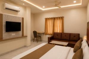 a hotel room with a bed and a couch and a table at Hotel Vaarahi Chanda Nagar, Near Hitech City in Hyderabad +23 photos