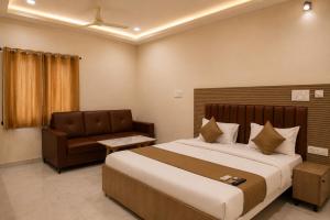 a bedroom with a large bed and a couch at Hotel Vaarahi Chanda Nagar, Near Hitech City in Hyderabad